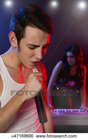 Stock Image - Male singer and female keyboarder on stage. Fotosearch