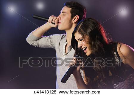 Stock Photo - Man and woman singing on stage. Fotosearch