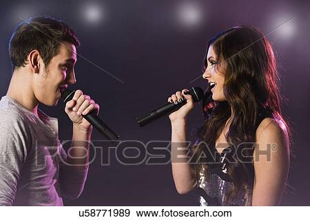 Stock Photo - Man and woman singing on stage. Fotosearch