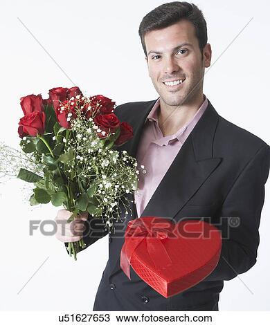 Man holding bouquet and Valentine's gift, portrait View Large Photo Image Stock Image - Man holding bouquet and Valentine's gift, portrait. Fotosearch