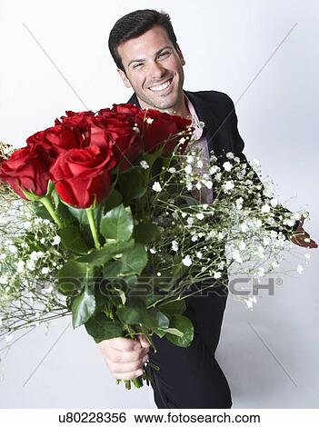 Stock Photograph - Man holding bouquet of roses, portrait. Fotosearch