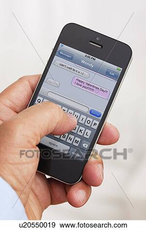 Man holding smartphone and texting View Large Photo Image Stock Photo - Man holding smartphone and texting . Fotosearch