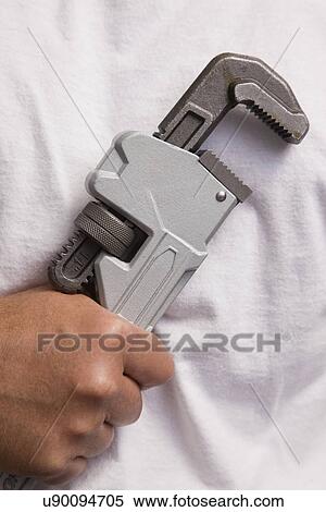 Stock Photography - Man holding wrench, close-up of hand. Fotosearch