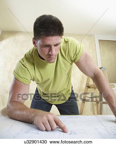Man looking at blueprint View Large Photo Image Stock Image - Man looking at blueprint. Fotosearch