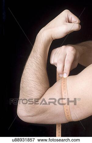 Man measuring bicep View Large Photo Image Stock Photo - Man measuring bicep. Fotosearch