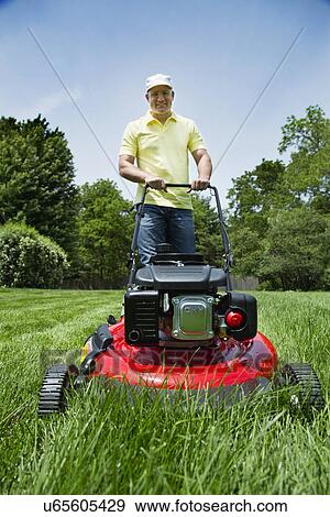Man mowing lawn View Large Photo Image Stock Photo - Man mowing lawn. Fotosearch