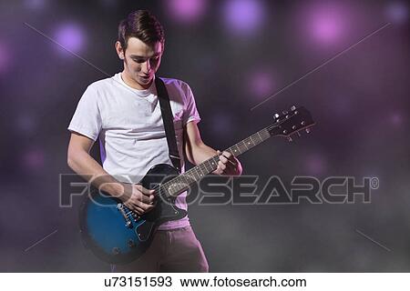 Stock Image - Man playing electric guitar. Fotosearch