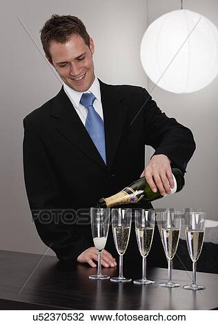 Man pouring champagne into glasses View Large Photo Image Stock Image - Man pouring champagne into glasses. Fotosearch