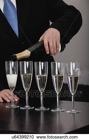 Man pouring champagne into glasses View Large Photo Image Stock Image - Man pouring champagne into glasses. Fotosearch