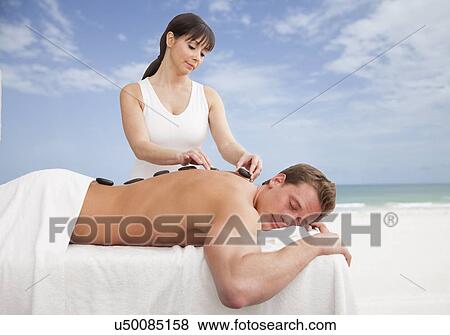 Stock Photo - Man receiving la stone therapy. Fotosearch