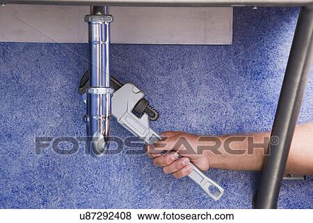 Man repairing pipe with wrench, close-up View Large Photo Image Stock Photo - Man repairing pipe with wrench, close-up. Fotosearch