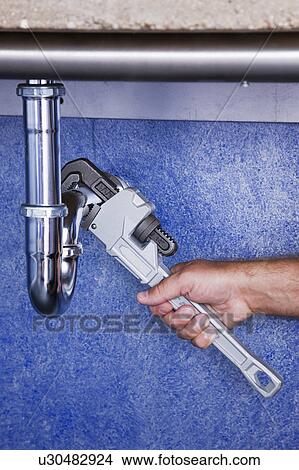 Man repairing pipe with wrench, close-up of hand View Large Photo Image Picture - Man repairing pipe with wrench, close-up of hand. Fotosearch