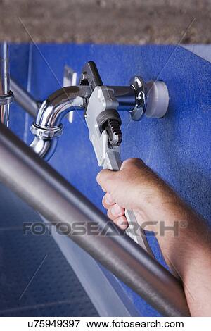 Man repairing pipe with wrench, close-up of hand View Large Photo Image Stock Photo - Man repairing pipe with wrench, close-up of hand. Fotosearch