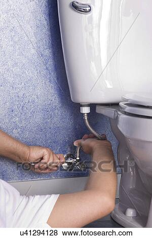 Man repairing toilet, close-up View Large Photo Image Stock Photo - Man repairing toilet, close-up. Fotosearch