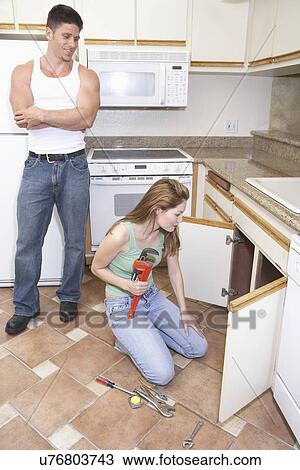 Man watching female plumber fixing kitchen sink View Large Photo Image Stock Image - Man watching female plumber fixing kitchen sink. Fotosearch