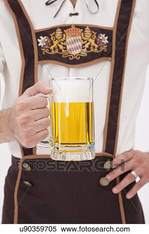 Man wearing Oktoberfest costume holding mug of beer View Large Photo Image Stock Photography - Man wearing Oktoberfest costume holding mug of beer. Fotosearch