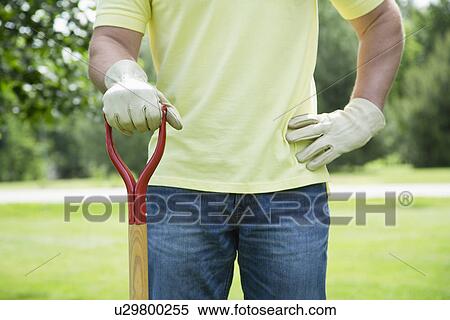 man with gardening tool standing in back yard View Large Photo Image Stock Photography - man with gardening tool standing in back yard. Fotosearch