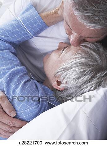 Mature couple embracing in bed View Large Photo Image Stock Image - Mature couple embracing in bed. Fotosearch