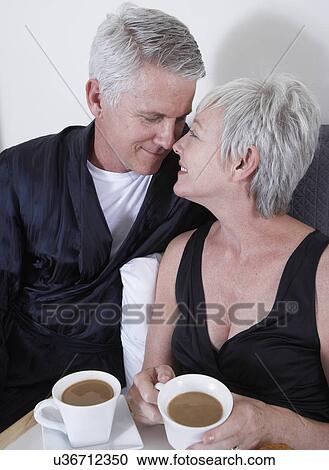 Mature couple having coffee in bed View Large Photo Image Stock Image - Mature couple having coffee in bed. Fotosearch