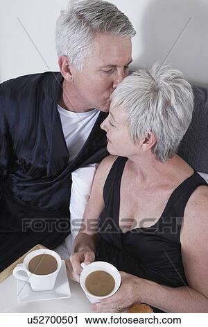 Mature couple having coffee in bed View Large Photo Image Stock Image - Mature couple having coffee in bed. Fotosearch