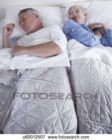 Stock Photo - Mature couple in bed. Fotosearch