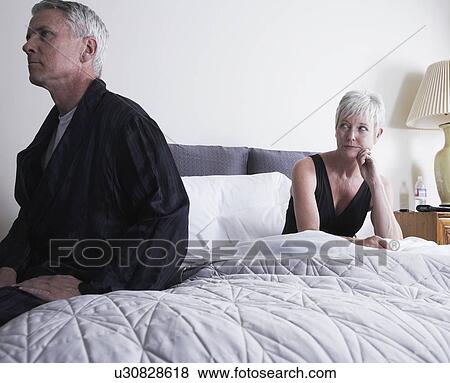 Mature couple sitting apart on bed View Large Photo Image Stock Photo - Mature couple sitting apart on bed. Fotosearch