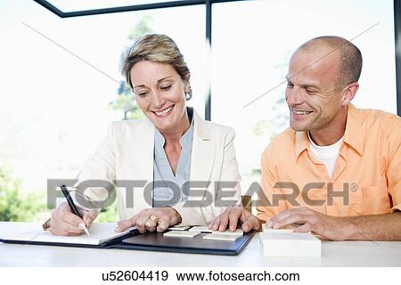 Mature man and interior designer choosing tile sample, smiling View Large Photo Image Stock Photo - Mature man and interior designer choosing tile sample, smiling. Fotosearch