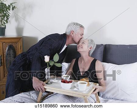 Mature man serving breakfast to woman in bed View Large Photo Image Stock Image - Mature man serving breakfast to woman in bed. Fotosearch