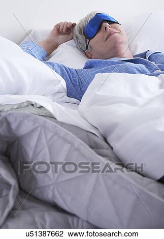 Mature woman wearing sleep mask lying in bed View Large Photo Image Stock Image - Mature woman wearing sleep mask lying in bed. Fotosearch