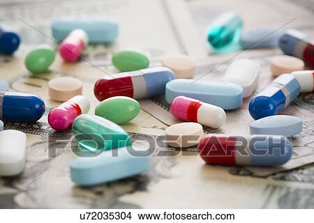 Medical pills and capsules lying on money View Large Photo Image Picture - Medical pills and capsules lying on money. Fotosearch