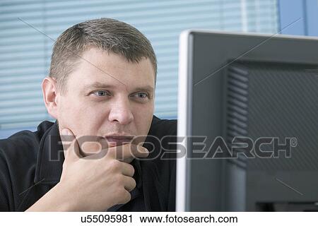 Mid adult man using computer View Large Photo Image Stock Image - Mid adult man using computer. Fotosearch