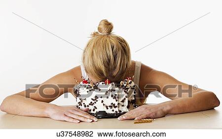 Mid adult woman with head in birthday cake, studio shot View Large Photo Image Stock Image - Mid adult woman with head in birthday cake, studio shot. Fotosearch