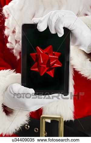 Mid section of Santa holding digital tablet View Large Photo Image Stock Photography - Mid section of Santa holding digital tablet. Fotosearch