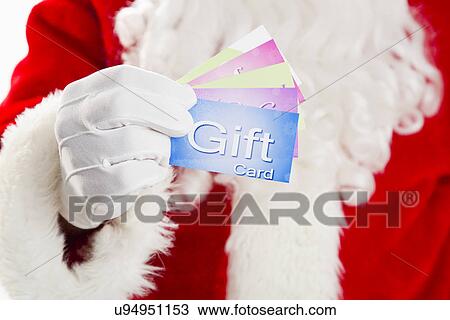 Stock Image - Mid section of Santa holding gift cards. Fotosearch