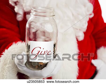 Stock Image - Mid section of Santa holding jar with coins. Fotosearch