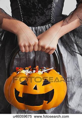 Midsection of teen girl holding jack o' lantern basket with candies View Large Photo Image Stock Photography - Midsection of teen girl holding jack o' lantern basket with candies. Fotosearch