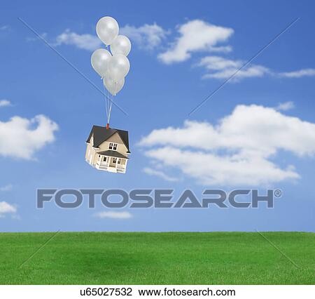Stock Image - Model house flying above grass with bunch of balloons. Fotosearch