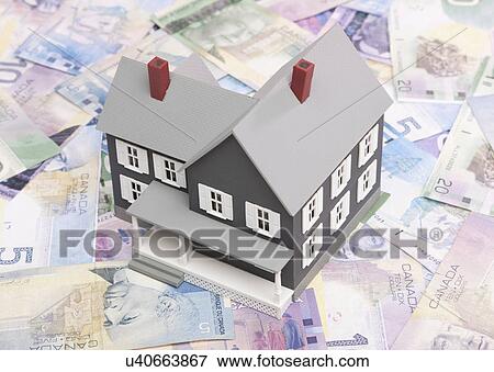 Stock Photo - Model house standing on banknotes. Fotosearch