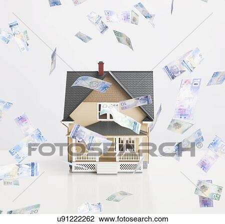 Stock Image - Model house surrounded by flying banknotes. Fotosearch
