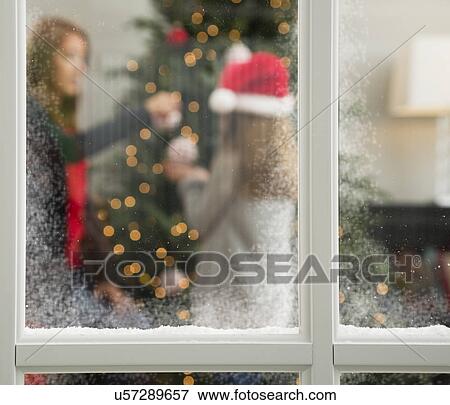 Stock Photo - Mother and daughter (8-9) decorating Christmas tree. Fotosearch
