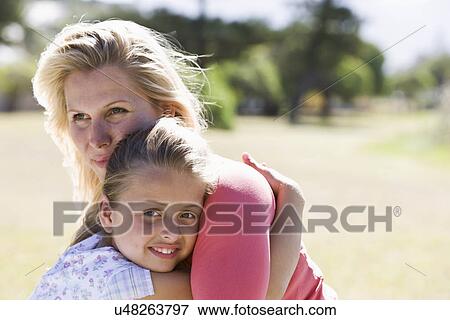 Mother and daughter (8-9) embracing in park View Large Photo Image Stock Photo - Mother and daughter (8-9) embracing in park. Fotosearch