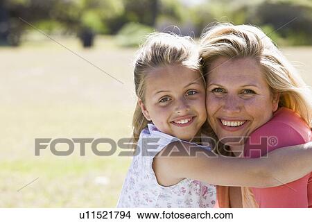 Mother and daughter (8-9) embracing, portrait View Large Photo Image Picture - Mother and daughter (8-9) embracing, portrait. Fotosearch