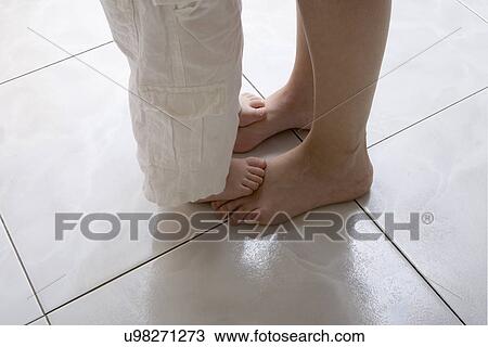 Stock Image - Mother and son dancing, low section. Fotosearch
