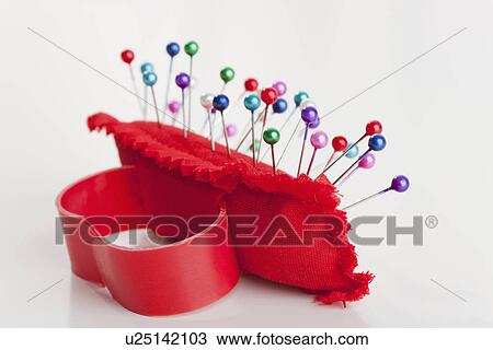 Stock Image - Multi colored pins in pin cushion. Fotosearch