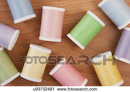 Stock Image - Multicolored spools on table top. Fotosearch