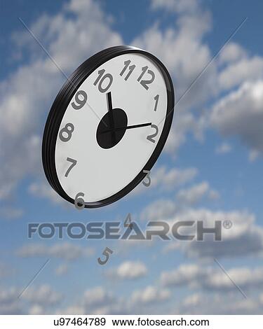 Stock Photo - Numbers falling from clock flying against sky, digital composite. Fotosearch