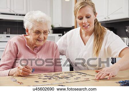 Nurse and senior woman playing puzzle View Large Photo Image Stock Image - Nurse and senior woman playing puzzle. Fotosearch
