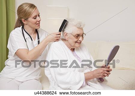 Picture - Nurse brushing senior woman's hair. Fotosearch