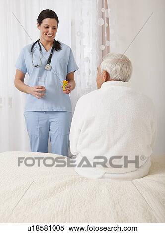 Nurse giving medicine to senior patient View Large Photo Image Stock Photography - Nurse giving medicine to senior patient. Fotosearch
