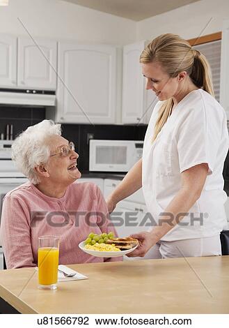 Nurse giving patient meal View Large Photo Image Stock Image - Nurse giving patient meal. Fotosearch